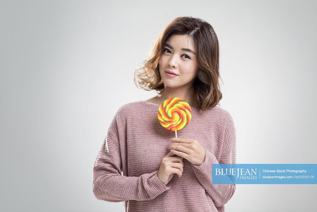 Young Chinese woman holding a lollipop