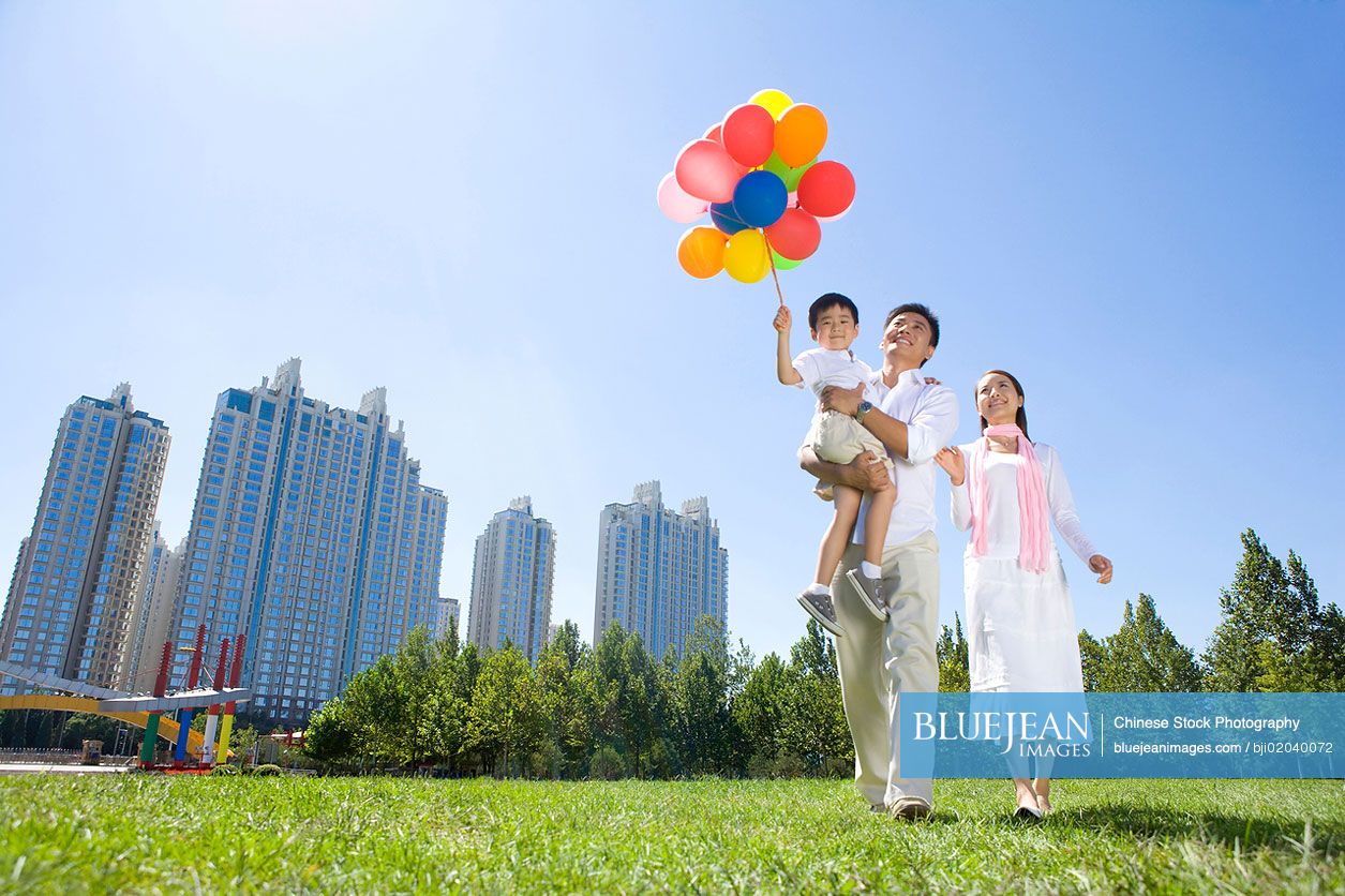 Young Chinese family in the park with balloons