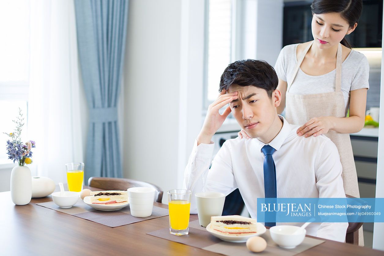 Young Chinese woman massaging her husband's shoulders