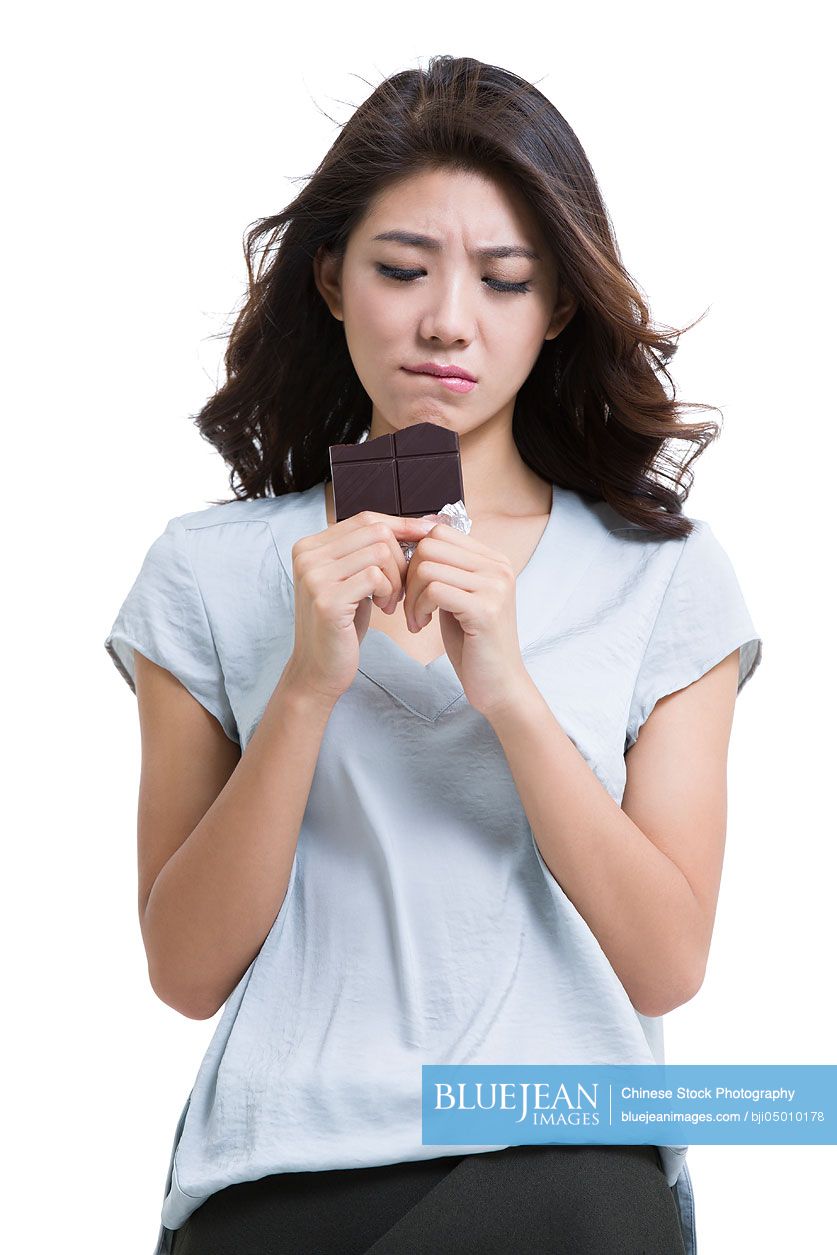 Young Chinese woman eating chocolate