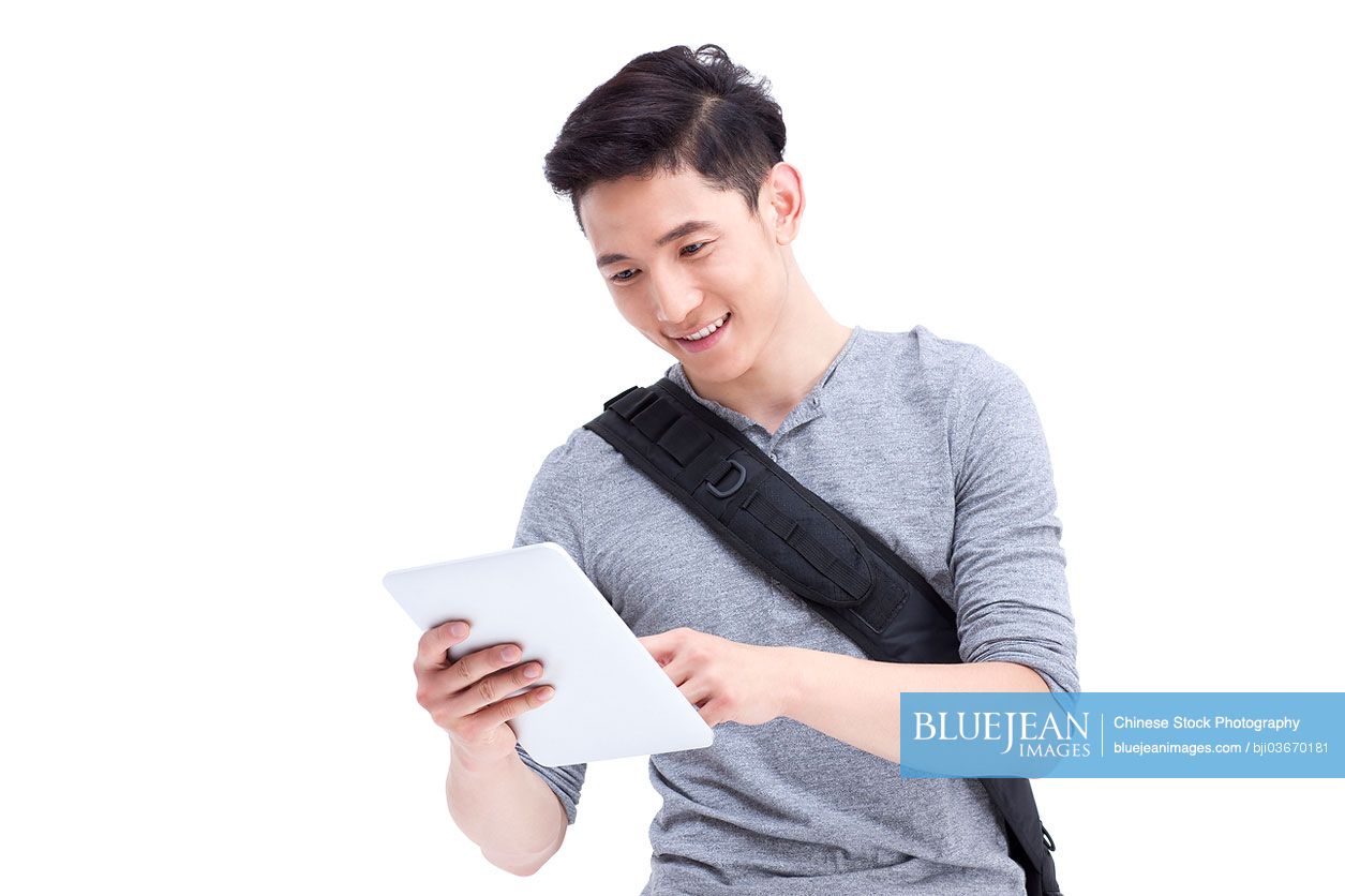 Happy male Chinese college student with digital tablet