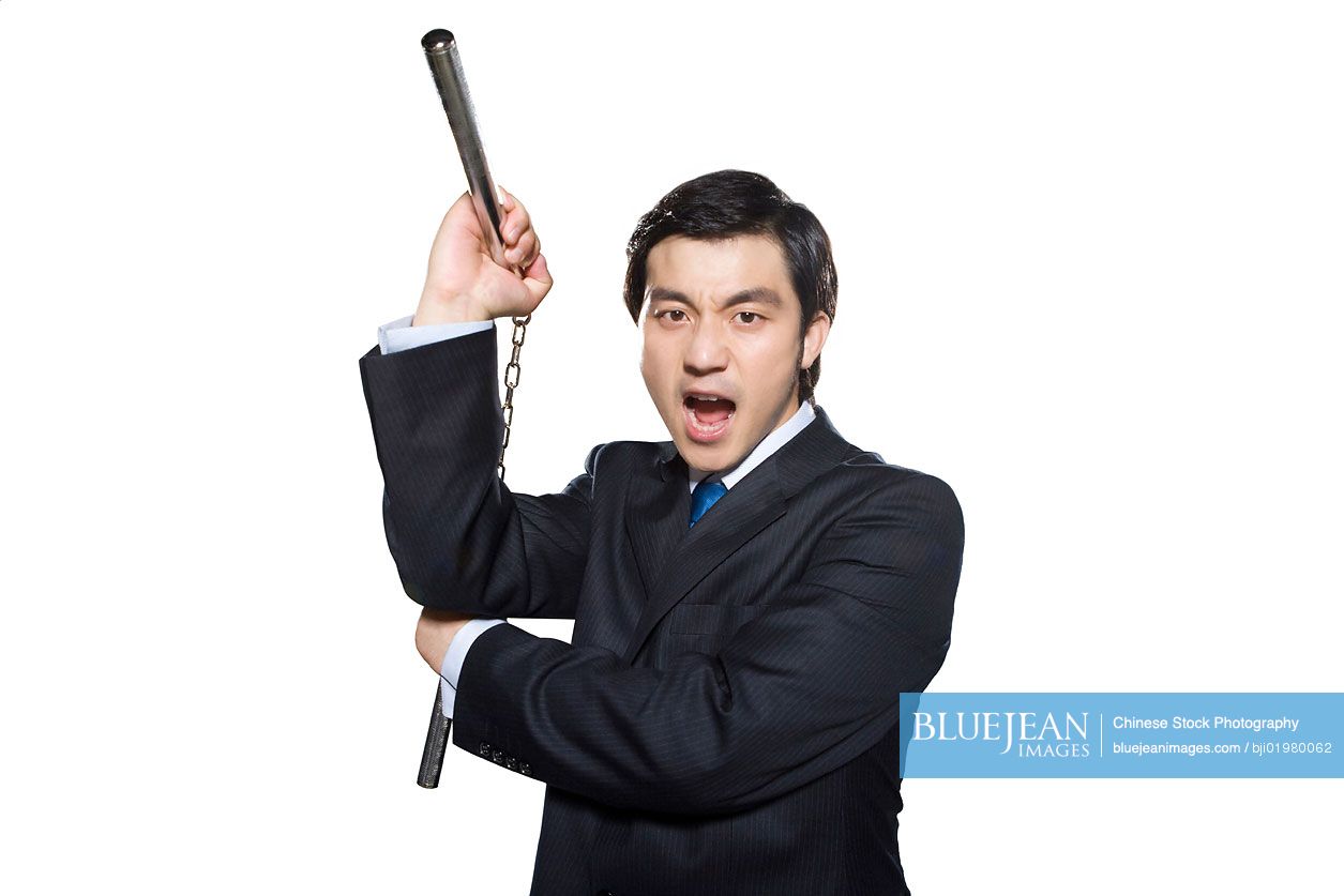 Angry Chinese businessman holding nunchukas