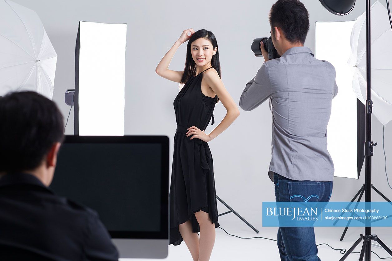 Chinese photographer taking pictures of female model in studio