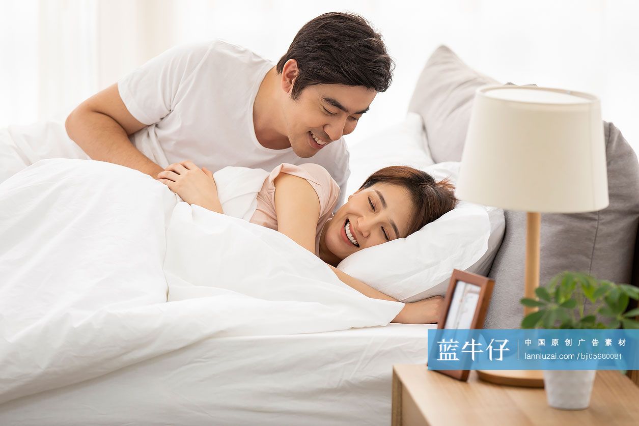 快乐的年轻情侣躺在床上睡觉-蓝牛仔影像-中国原创广告影像素材