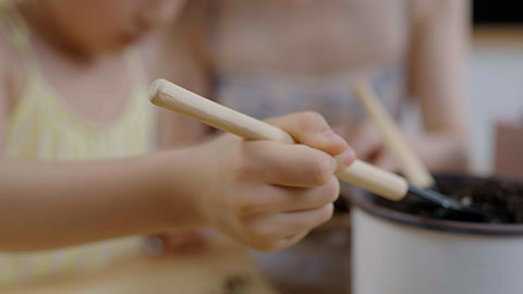 Mum and daughter enjoy potting plants together at home