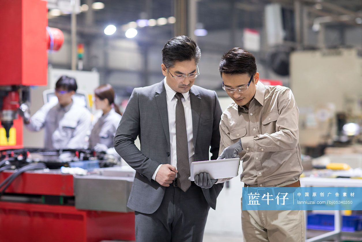商务男士和工程师在工厂讨论工作