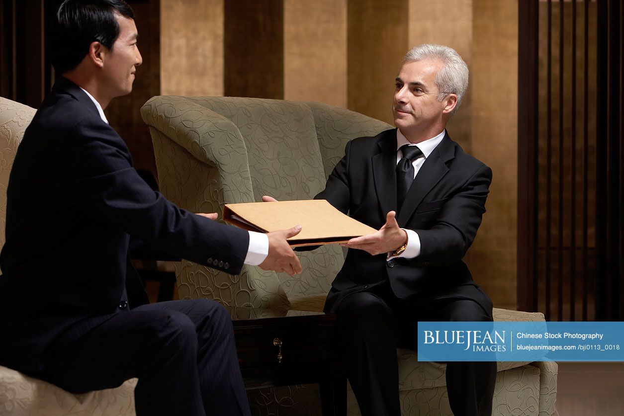 Two business leaders discuss cooperation at an exclusive business club