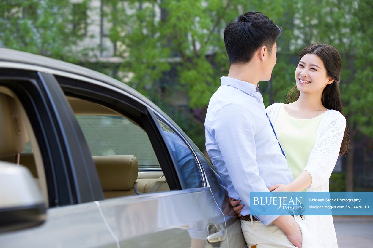 Happy young Chinese couple and car