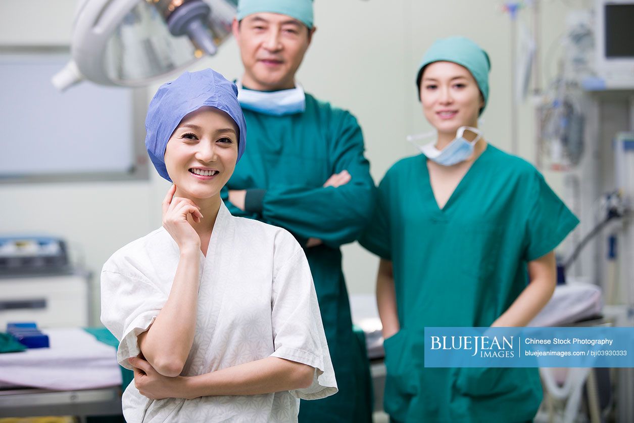 Chinese plastic surgeons with patient in operating room