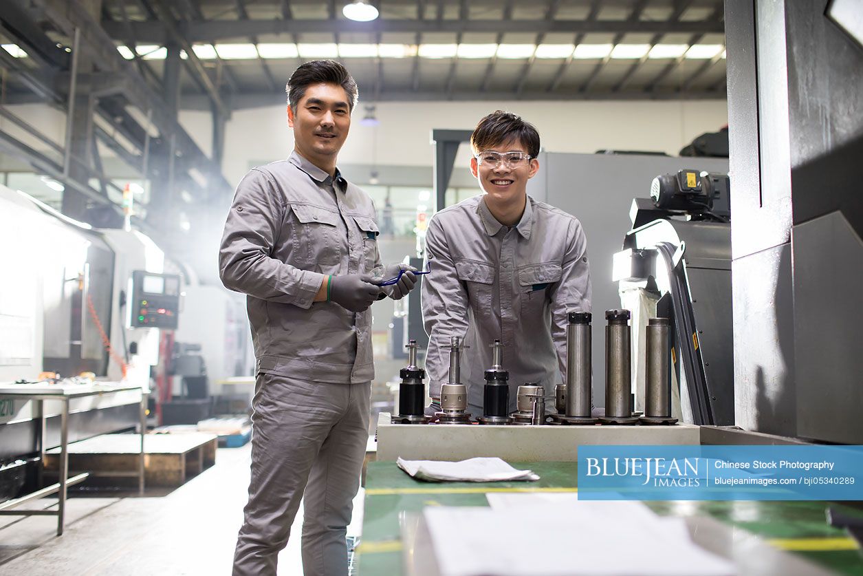 Confident Chinese engineers working in the factory