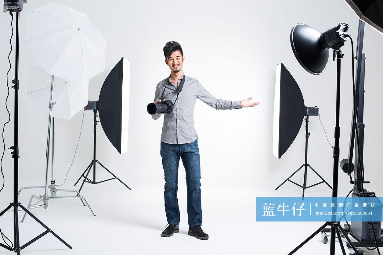 摄影师拿着相机站在摄影棚里