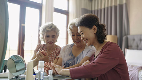 Senior Chinese friends applying moisturizer at home,4K