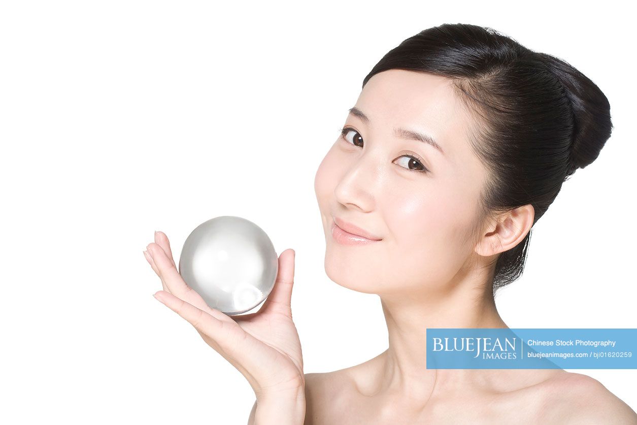 Beauty shot of a young Chinese woman holding a crystal ball