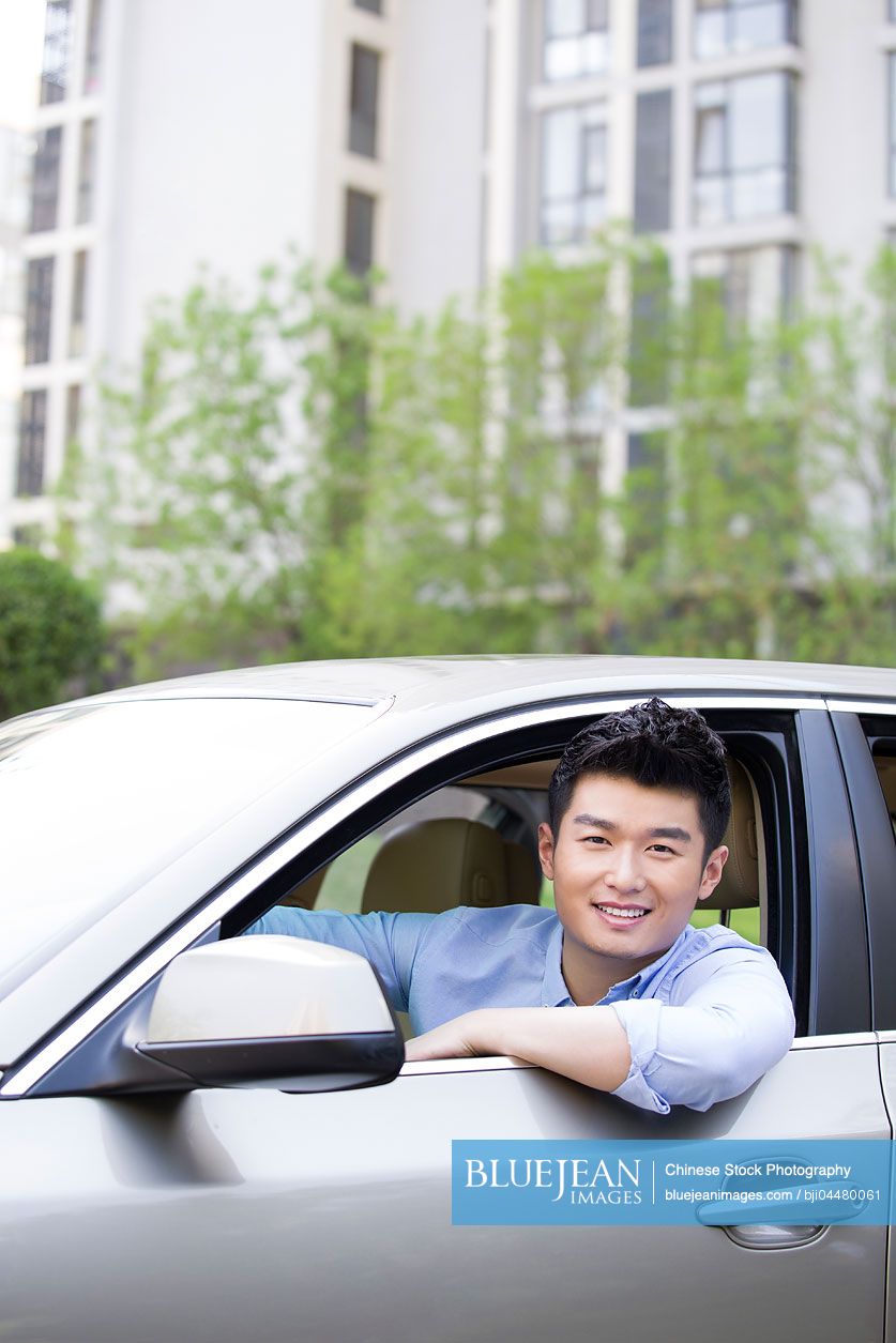 Young Chinese man driving car
