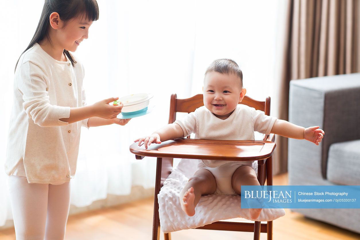 Little Chinese girl feeding baby