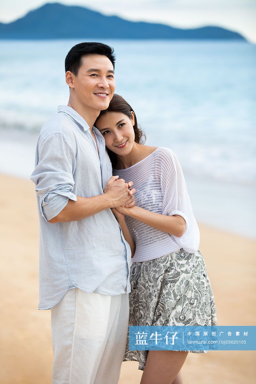 快乐的年轻夫妇在沙滩拥抱
