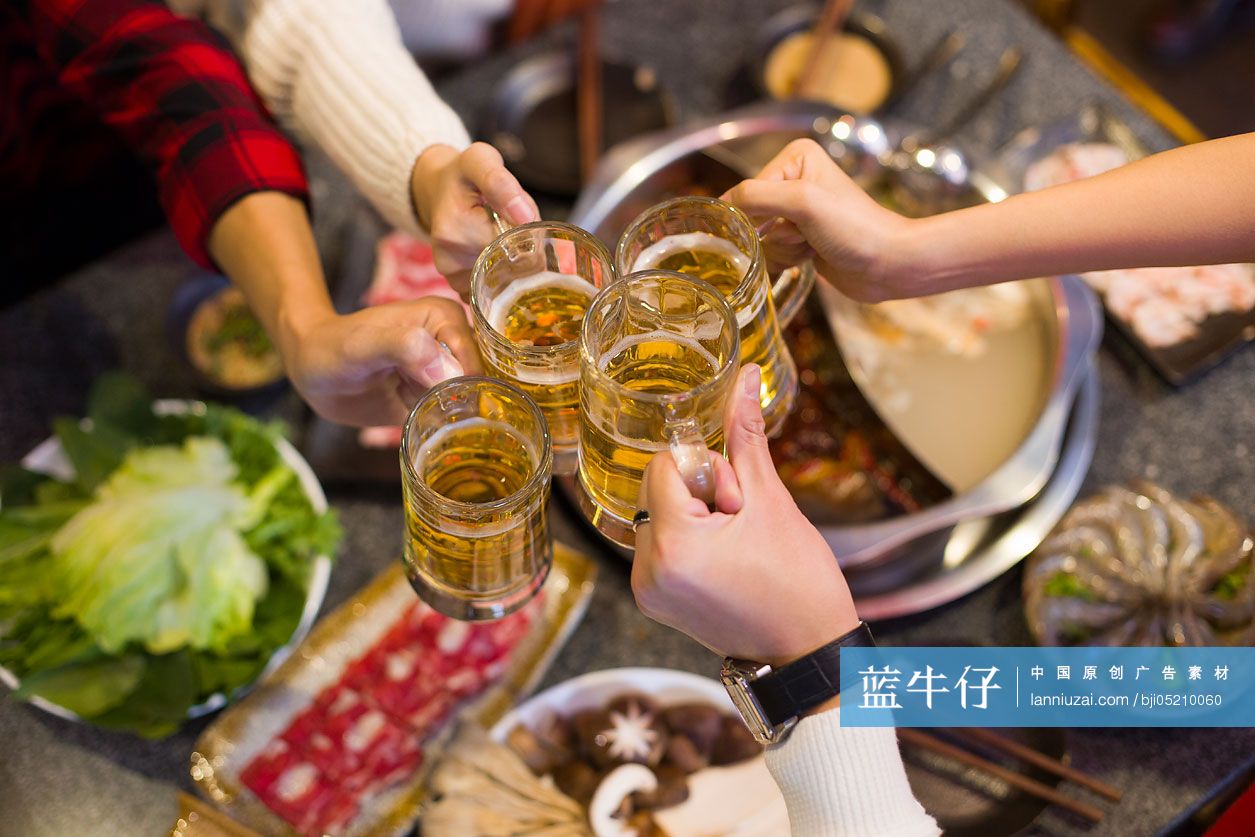 年轻朋友们在火锅店吃饭喝啤酒