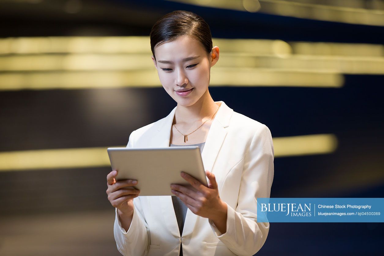 Chinese businesswoman using digital tablet outdoors