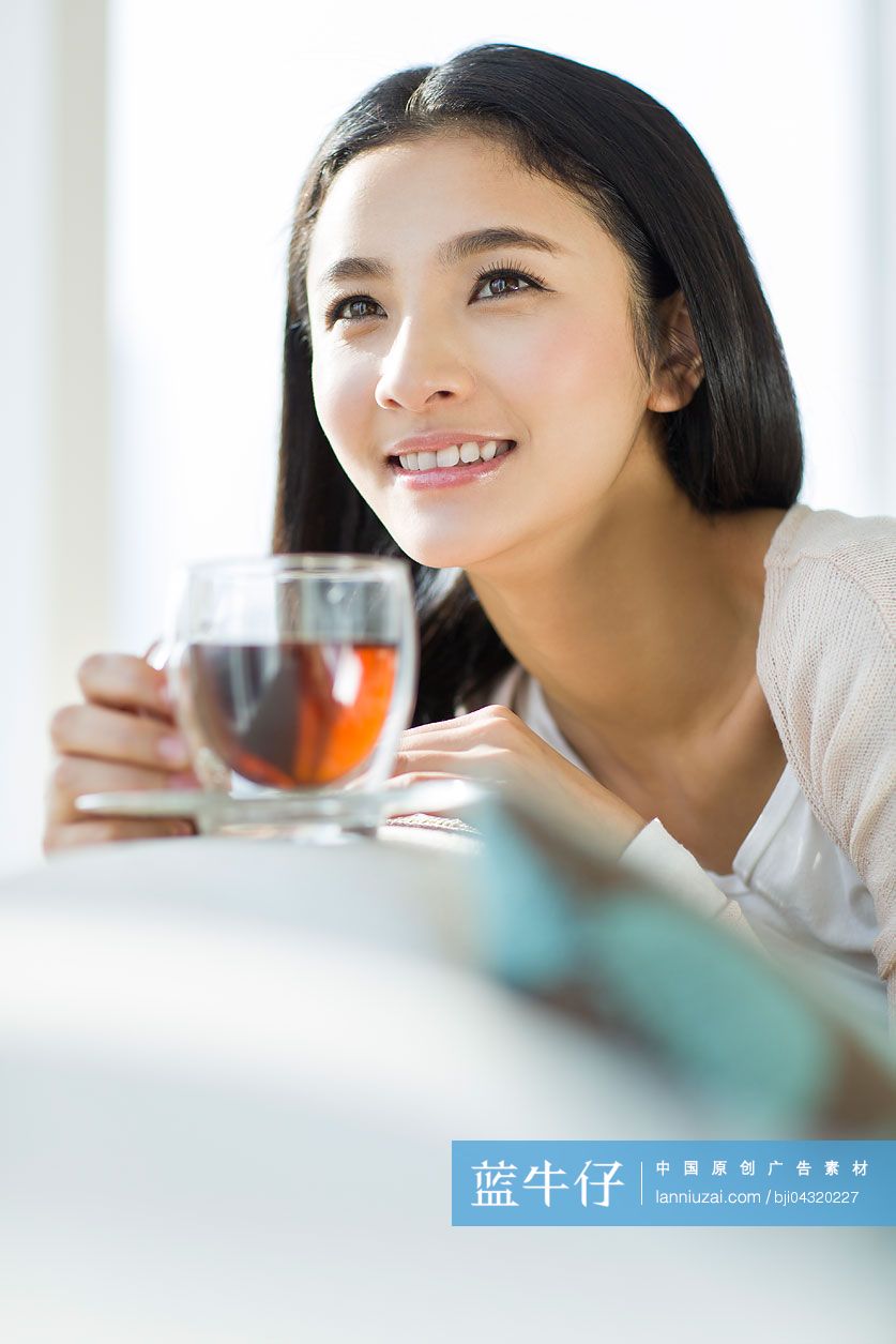 快乐的年轻女子喝红茶