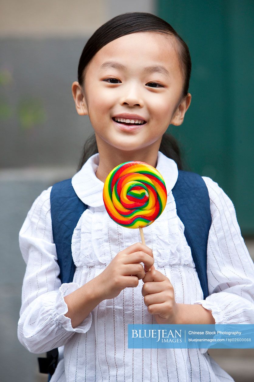 A happy Chinese girl with a lollipop