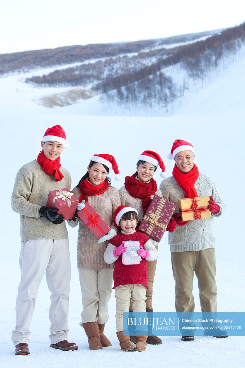 Happy Chinese family holding christmas gifts