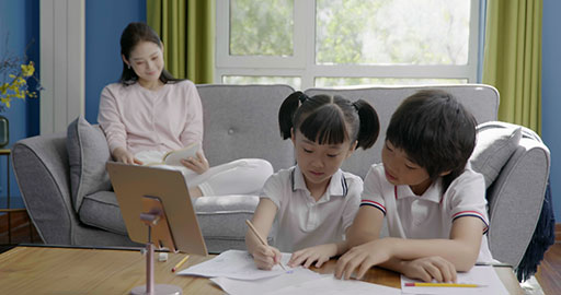 The kids attending a virtual class with their mom by their side