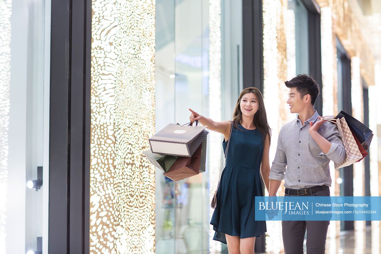 Happy young Chinese couple shopping