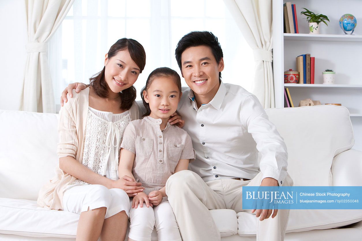 Happy Chinese family on a sofa