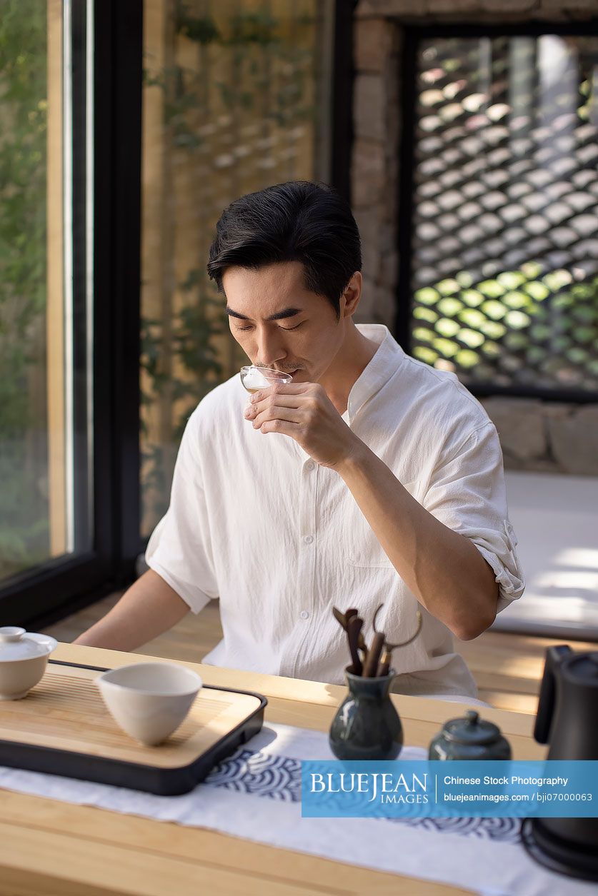 Mid adult Chinese man drinking tea in tea room