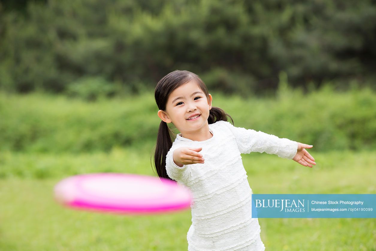 Happy Chinese boy playing frisbee