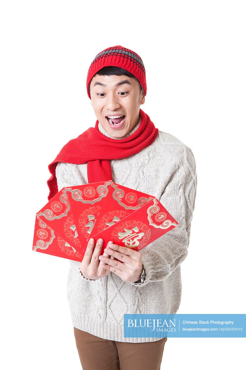 Excited young man with red envelops for Chinese New Year