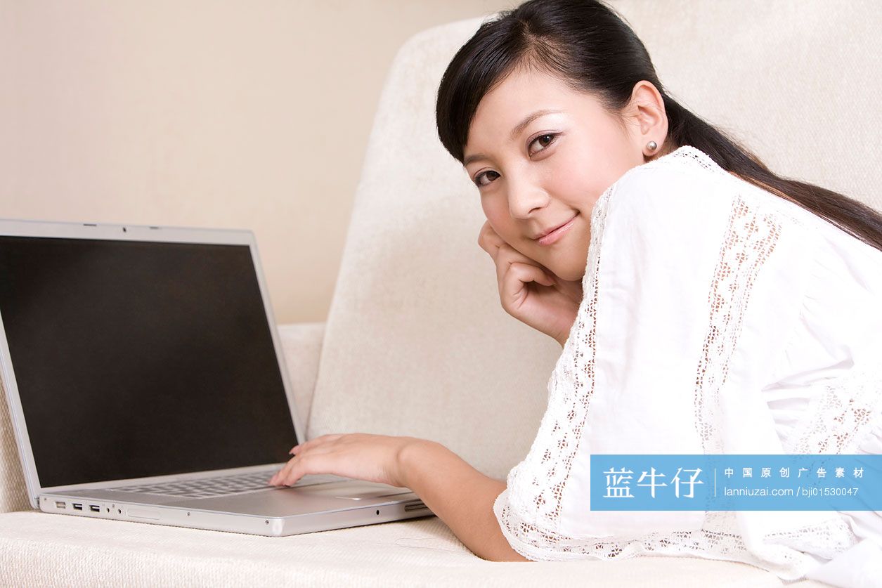 在沙发上用电脑的年轻女子