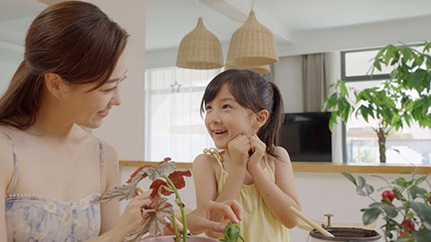 Mum and daughter enjoy potting plants together at home