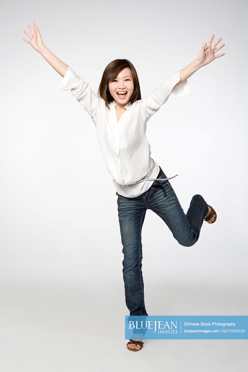 Portrait of young Chinese woman with arms outstretched