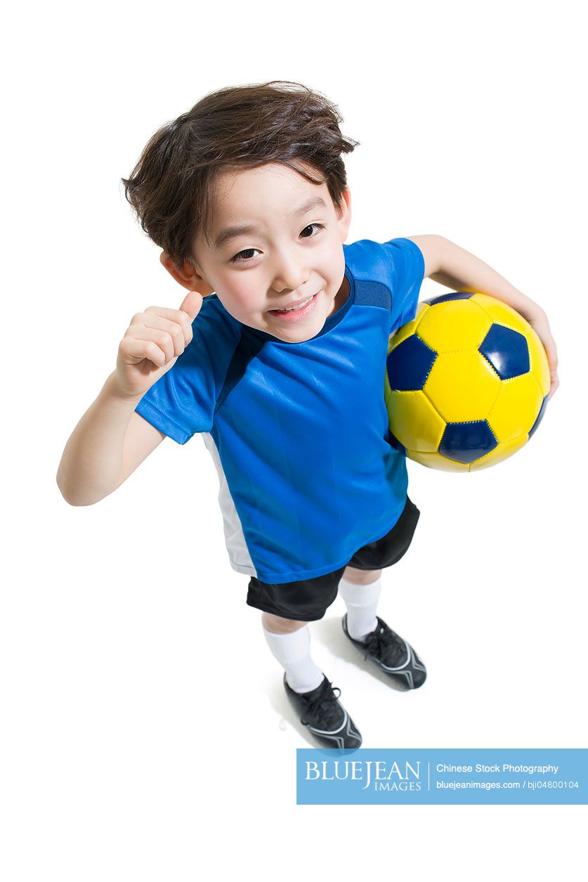 Cute Chinese boy holding a soccer ball