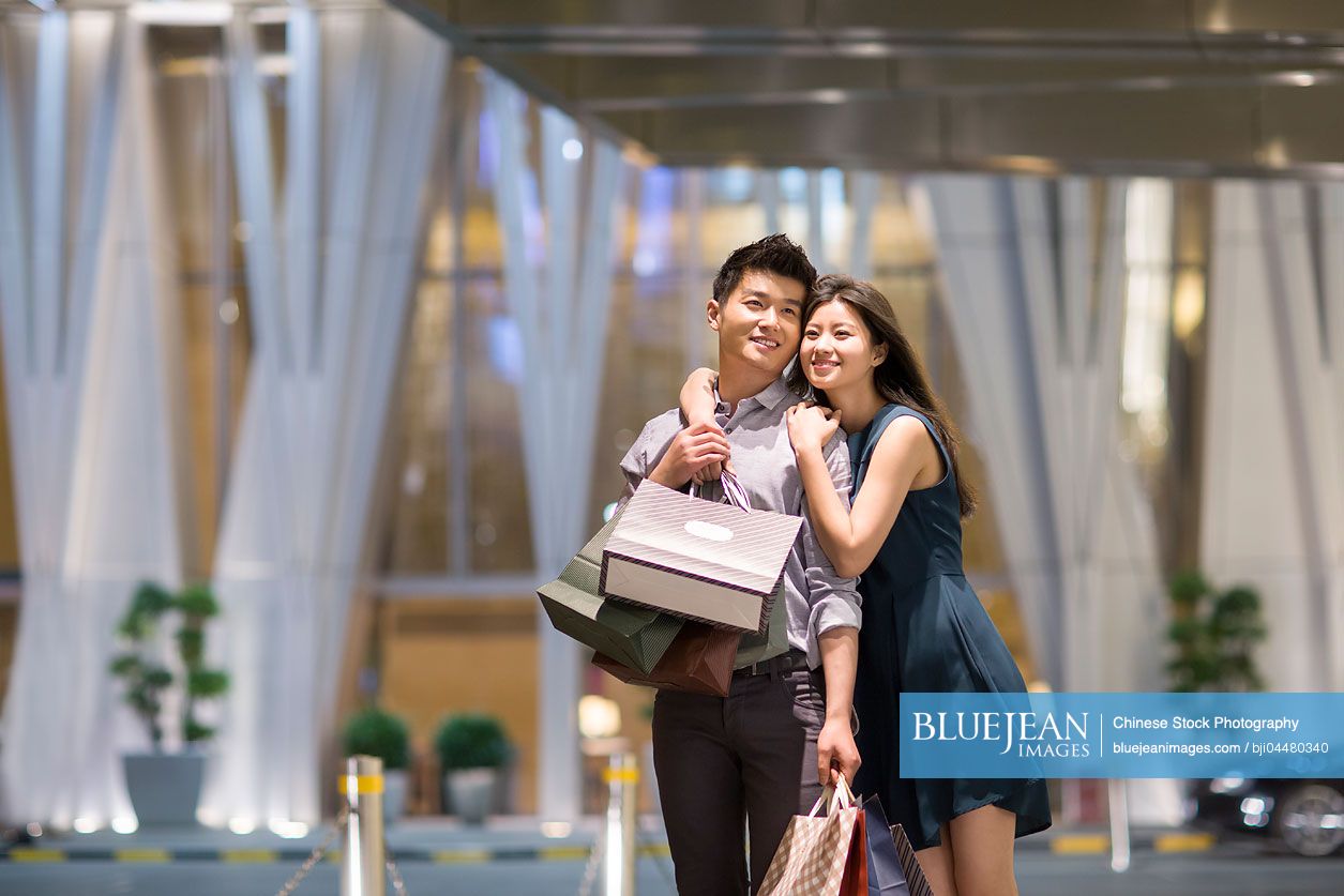 Happy young Chinese couple shopping