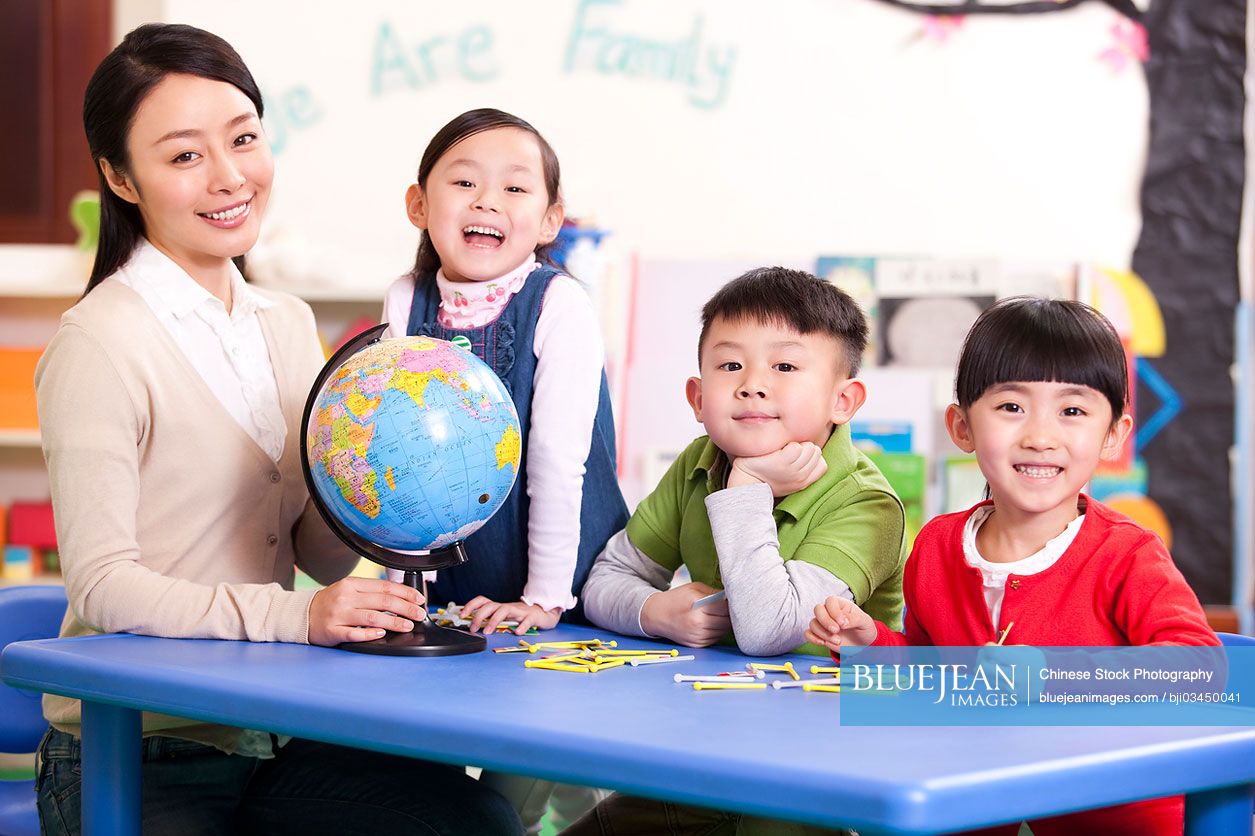 Female Chinese teacher teaching kindergarten children geography