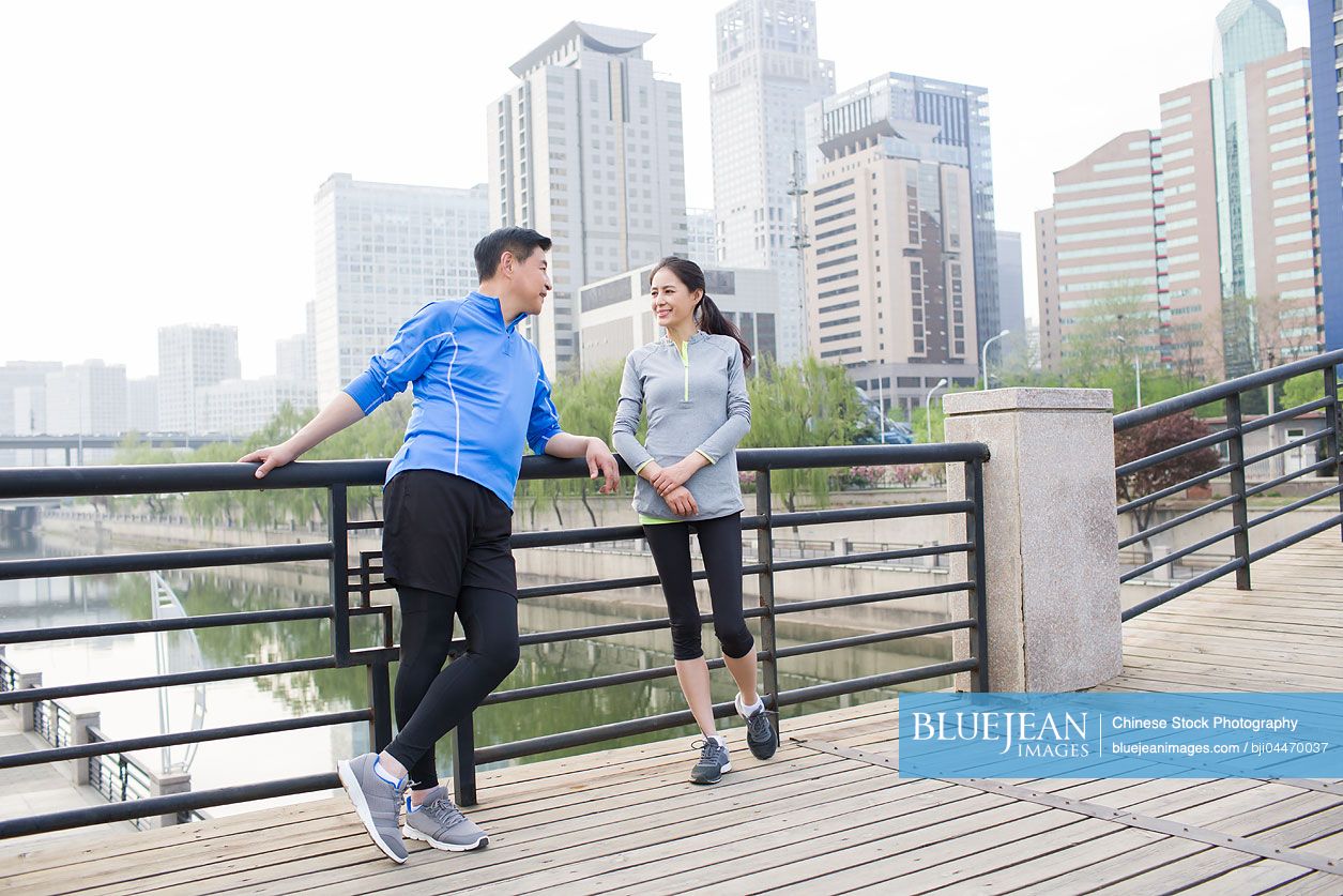 Happy mature Chinese couple resting after exercising