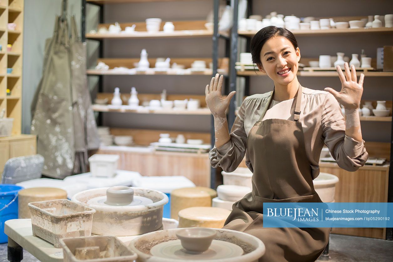 Young Chinese potter working on pottery wheel