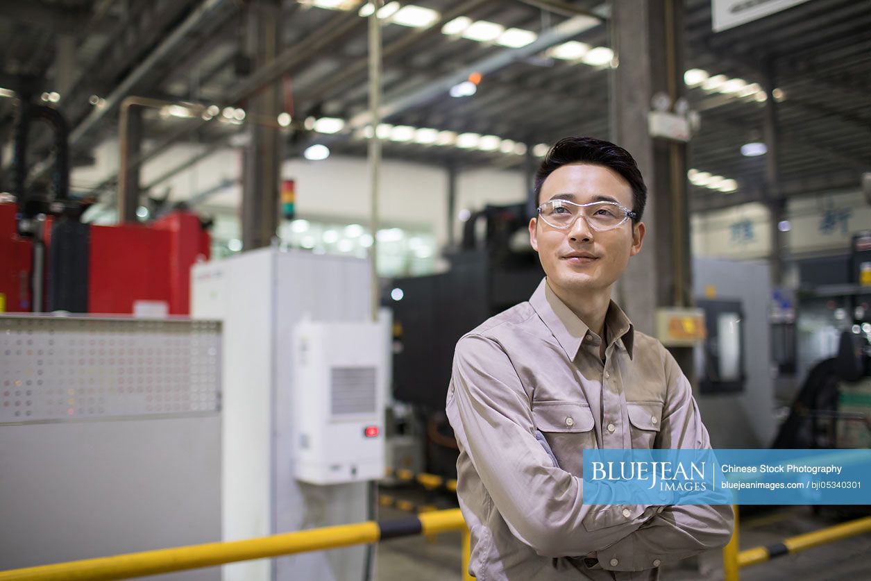 Confident Chinese engineer in the factory