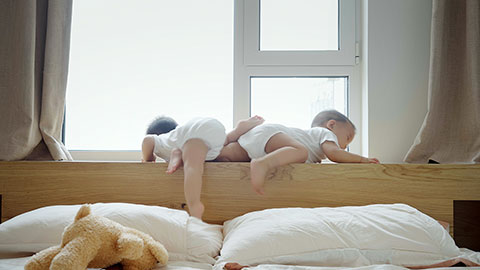 Two twin babies crawling in the bedroom