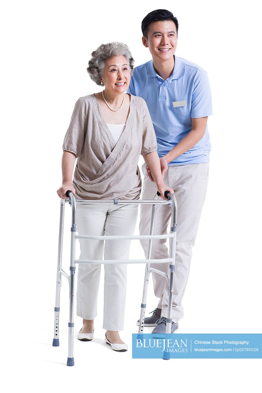 Chinese male nursing assistant helping senior woman with walking frame