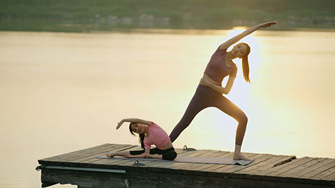 妈妈和女儿在公园练瑜伽