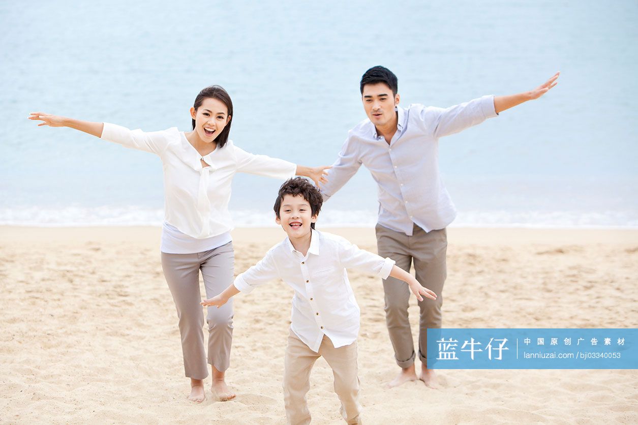快乐的一家三口在沙滩上玩耍