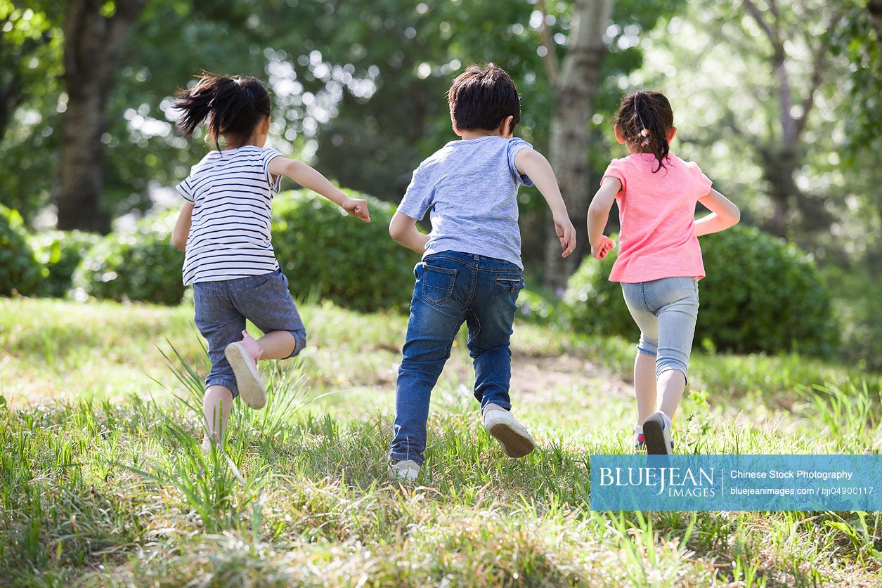 Happy Chinese children running in woods