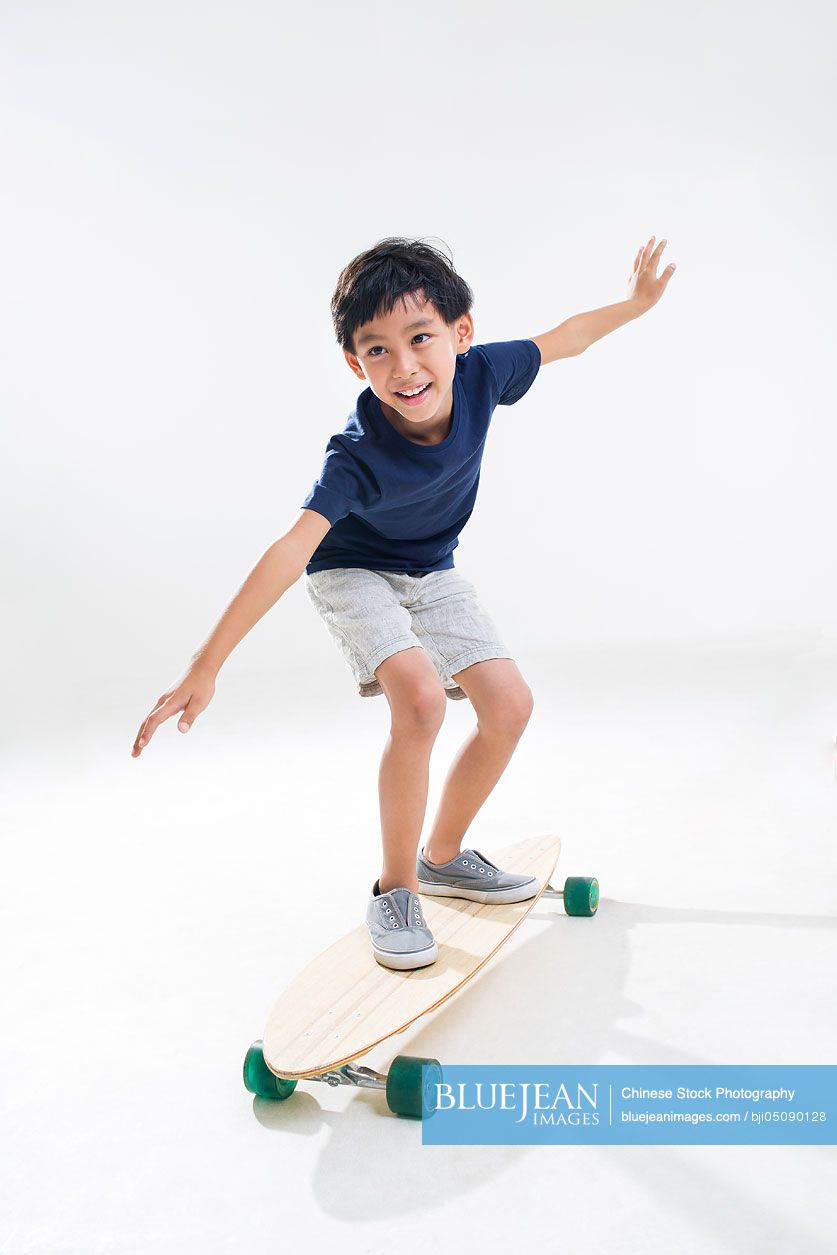 Cute little Chinese boy skateboarding