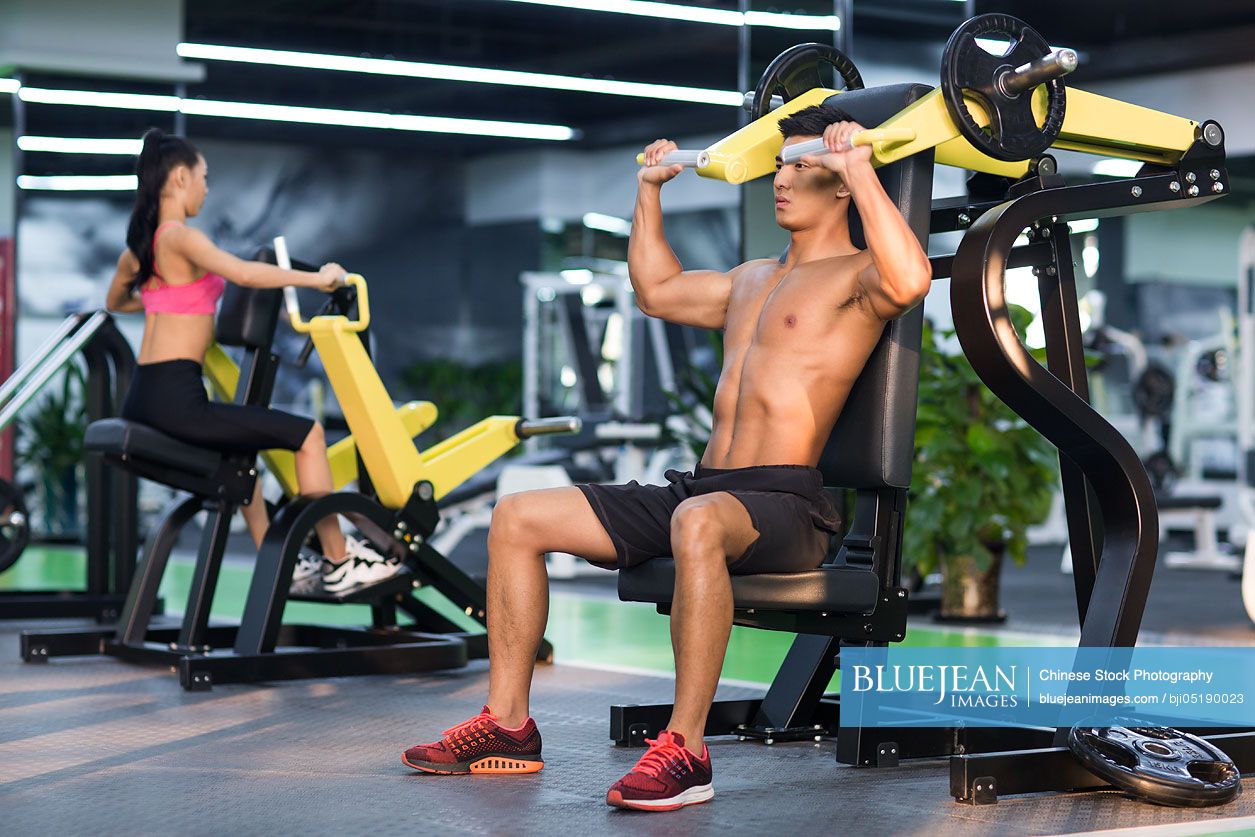 Young Chinese man exercising at gym