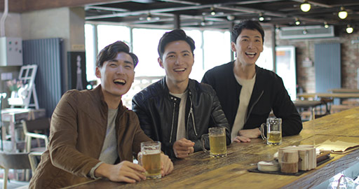 Happy young Chinese men drinking beer and cheering at bar,4k