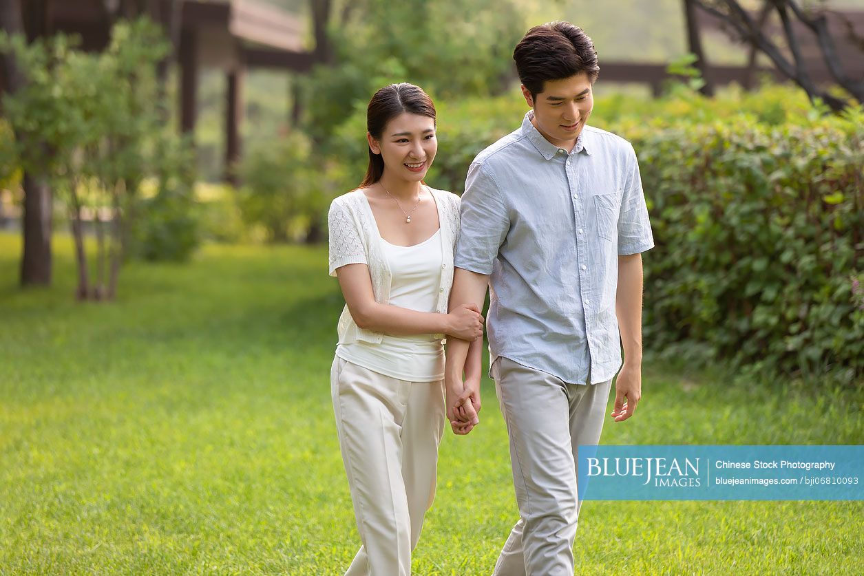 Happy young Chinese couple relaxing in park