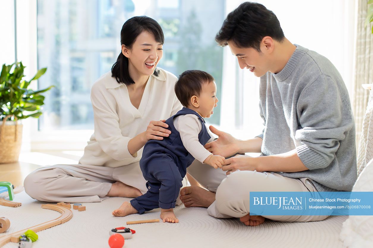 Young Chinese parents playing with baby at home